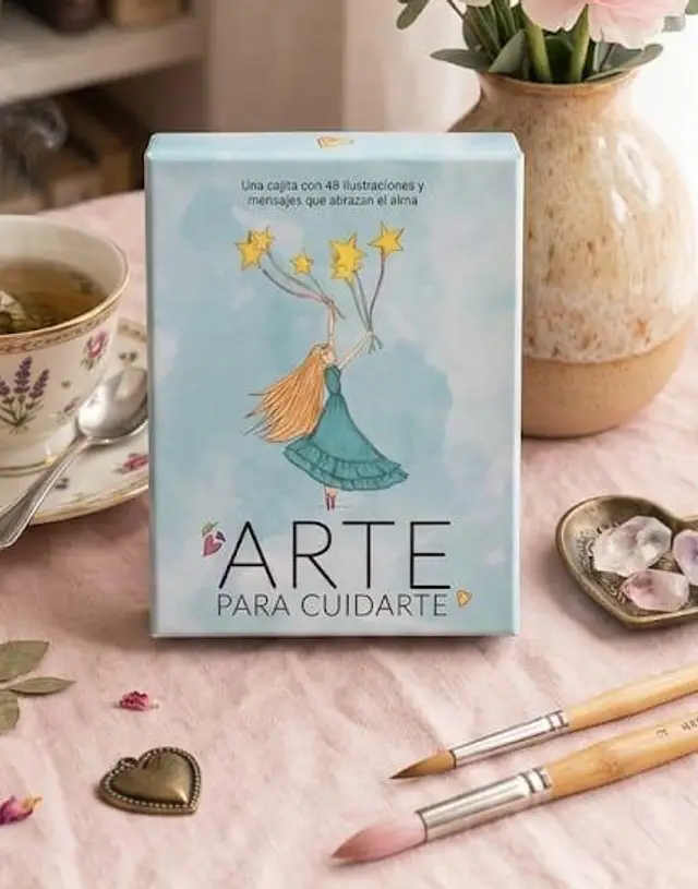 La cajita impresa sobre una mesa, junto a una taza de té, flores y pinceles.
