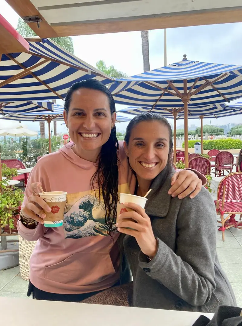 Tita y Eri sonriendo con un café después de nadar.